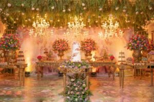 Lavishly decorated quinceañera venue with chandelier lighting and vibrant floral arrangements.