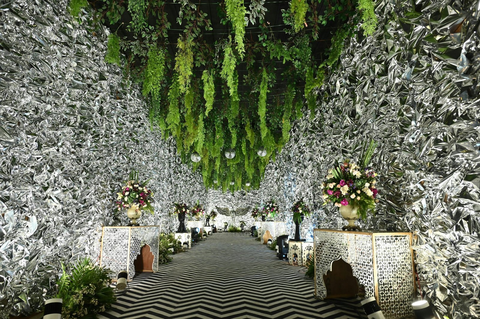 A lavishly decorated wedding venue in Jaipur, India featuring silver walls and lush greenery.