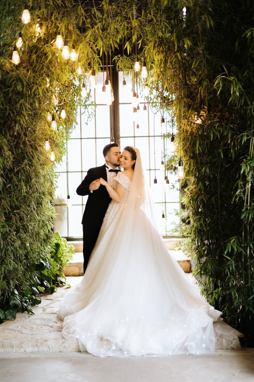 Beautiful bride and groom in an enchanted, lush garden setting, bathed in warm lighting and romance.